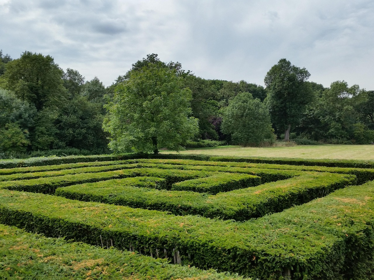 Labirinto antico nel castello inglese, circondato da mura storiche e vegetazione.