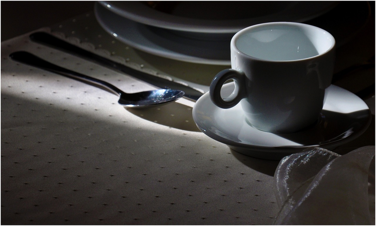 Tovaglia macchiata di caffè con prodotti per la pulizia e un panno per rimuovere le macchie.