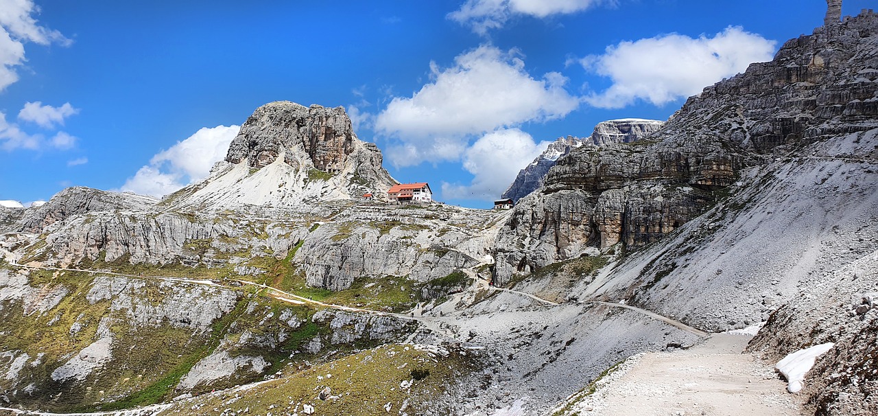 Escursionisti lungo l'Alta Via delle Dolomiti n.1, con panorami mozzafiato e rifugi immersi nella natura.