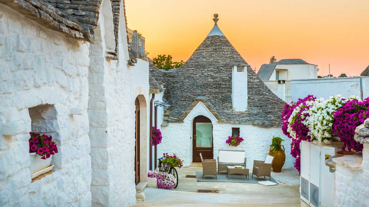 Trullo tradizionale pugliese immerso nella campagna, simbolo dell'ospitalità italiana.