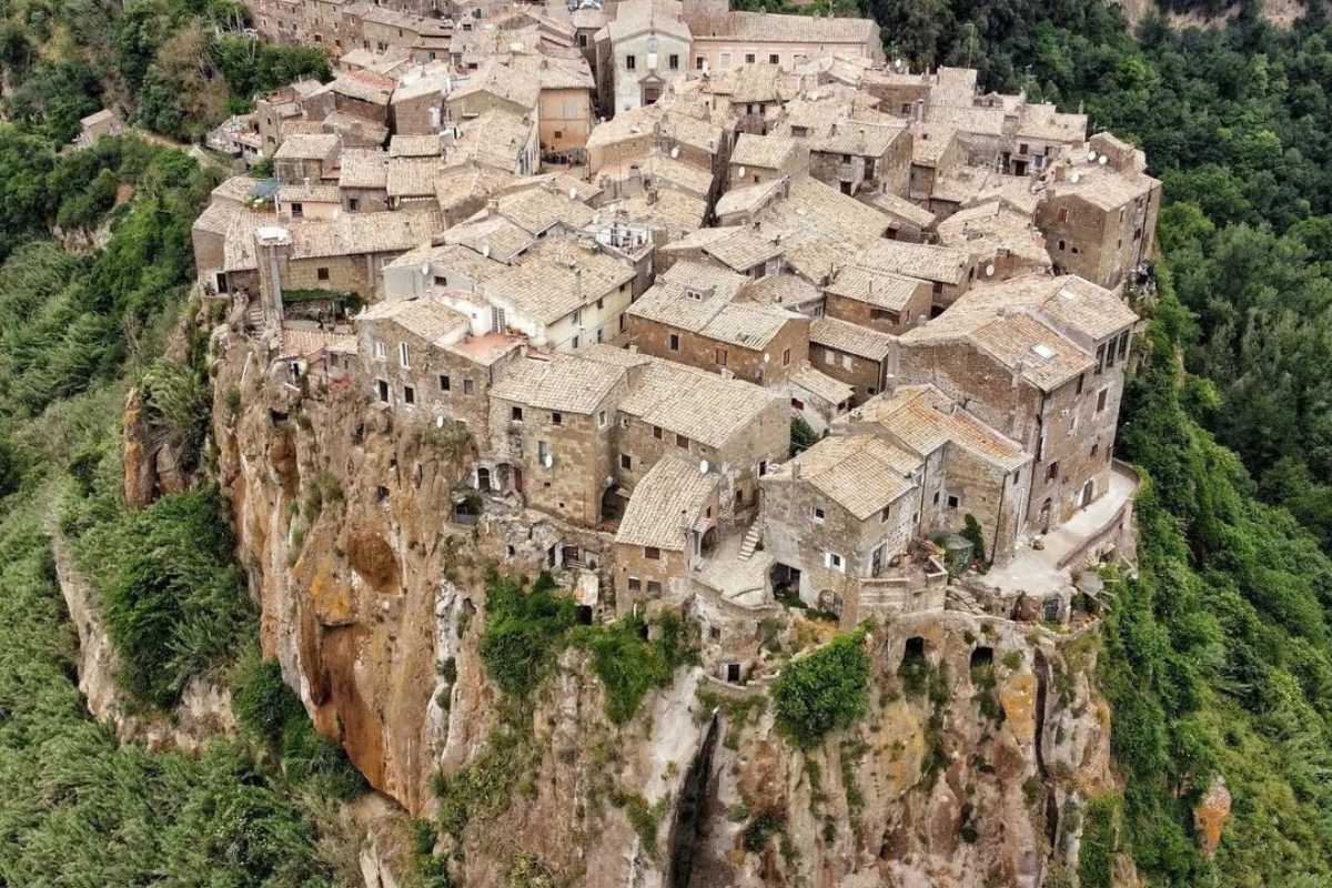 Borgo invisibile in Sicilia con case scolpite nella roccia, immerso nella natura.