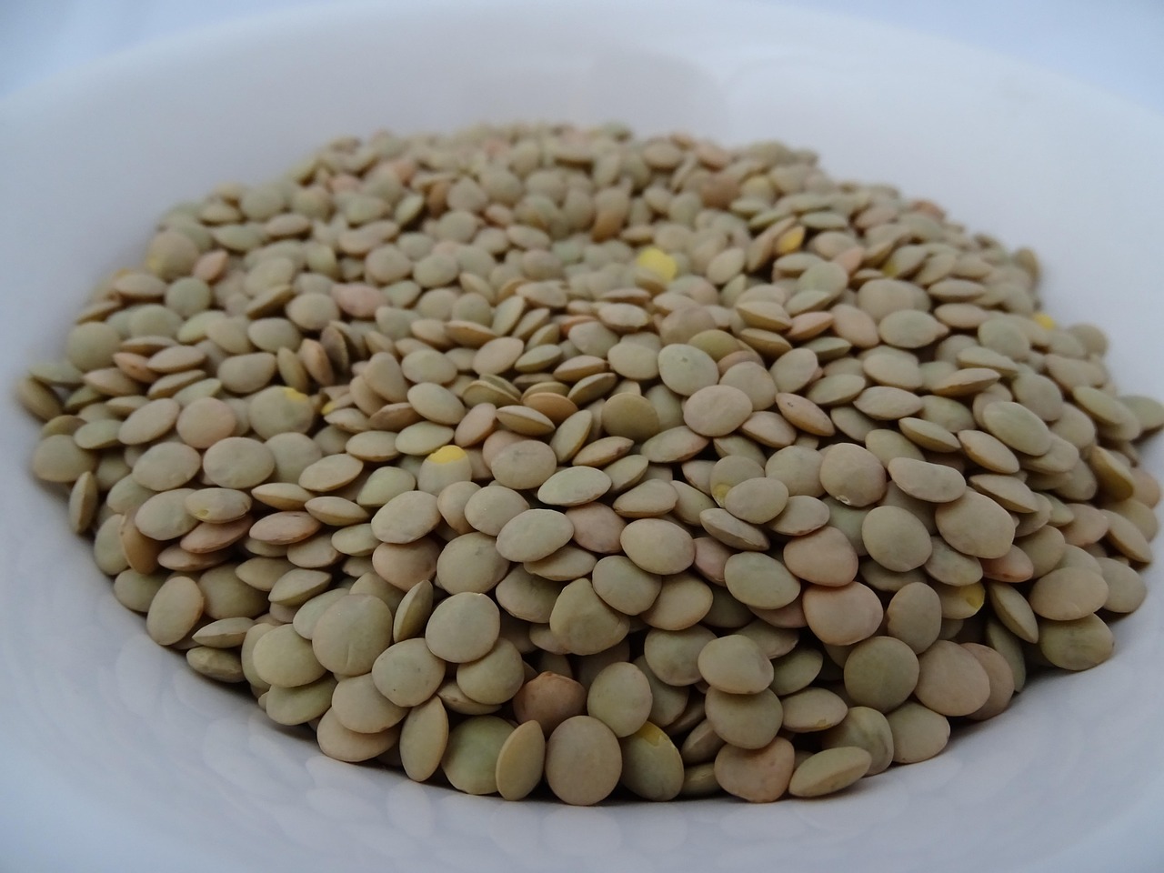 Lenticchie cotte con foglie di alloro su un piatto, simbolo di buon augurio per Capodanno.